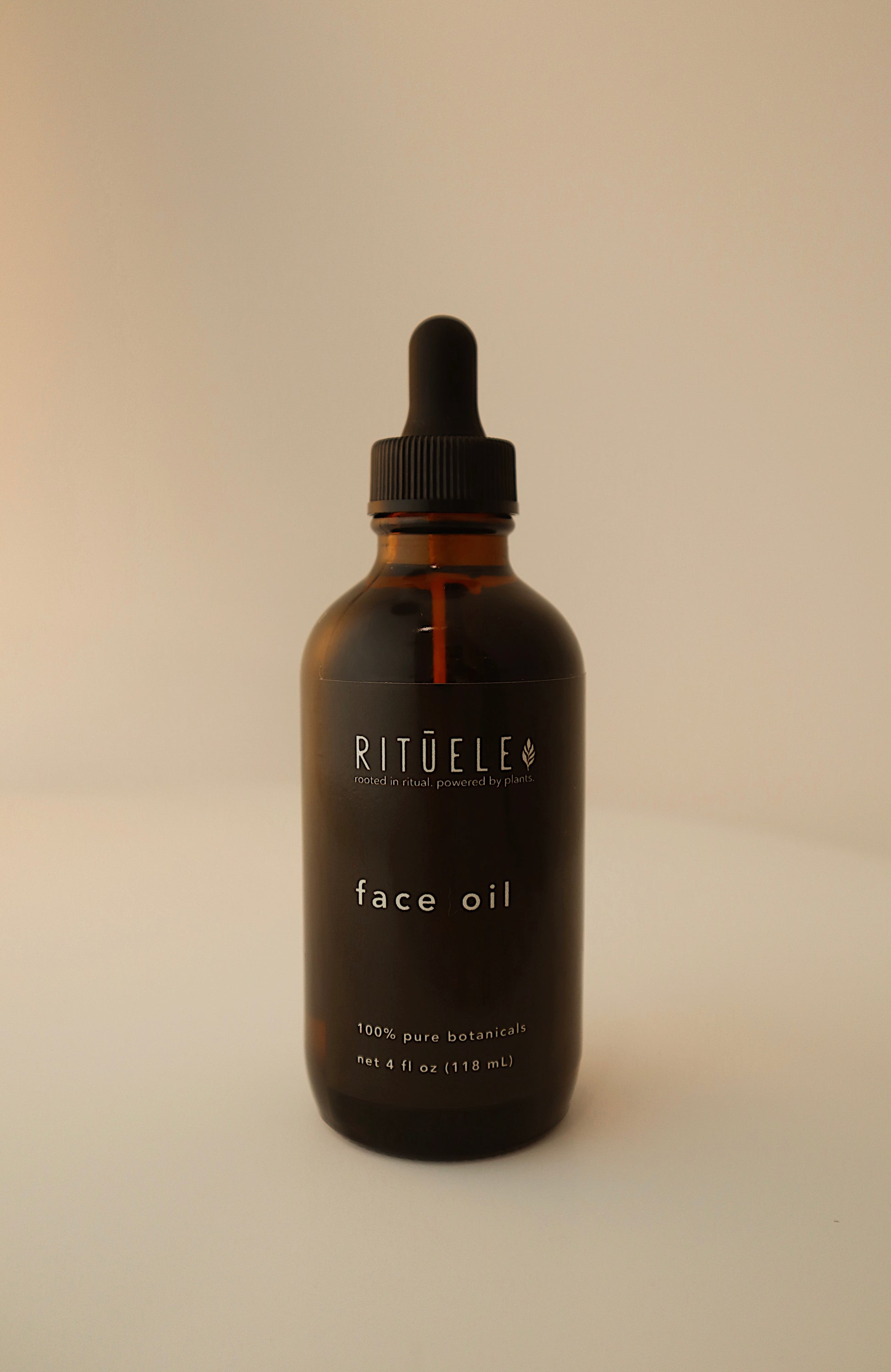 Bottle of Rituéle face oil on a beige background