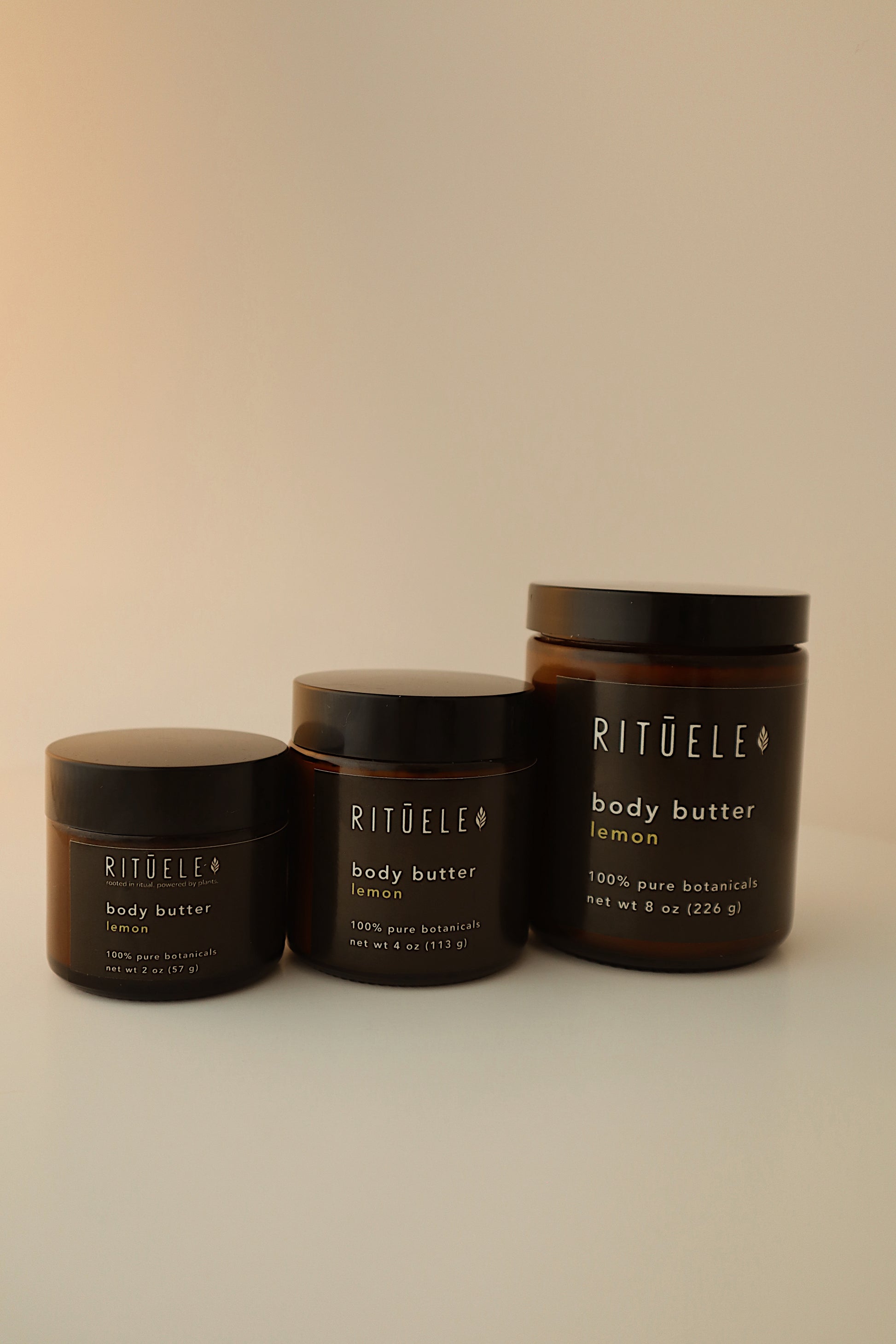 Three containers of rituele body butter on a beige background