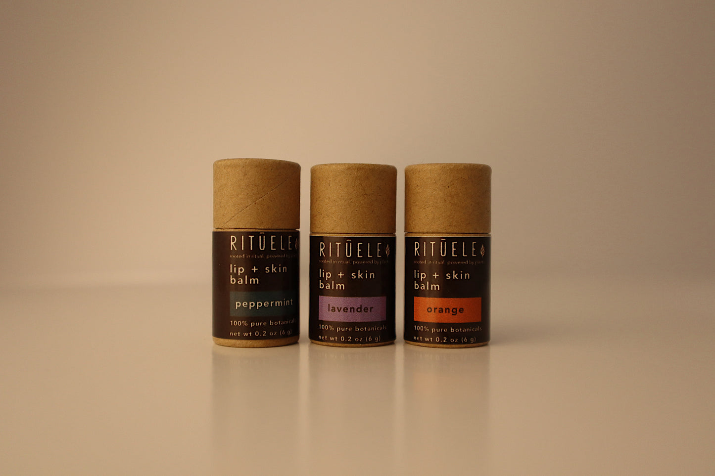 Three Rituele lip and skin balms on a beige background